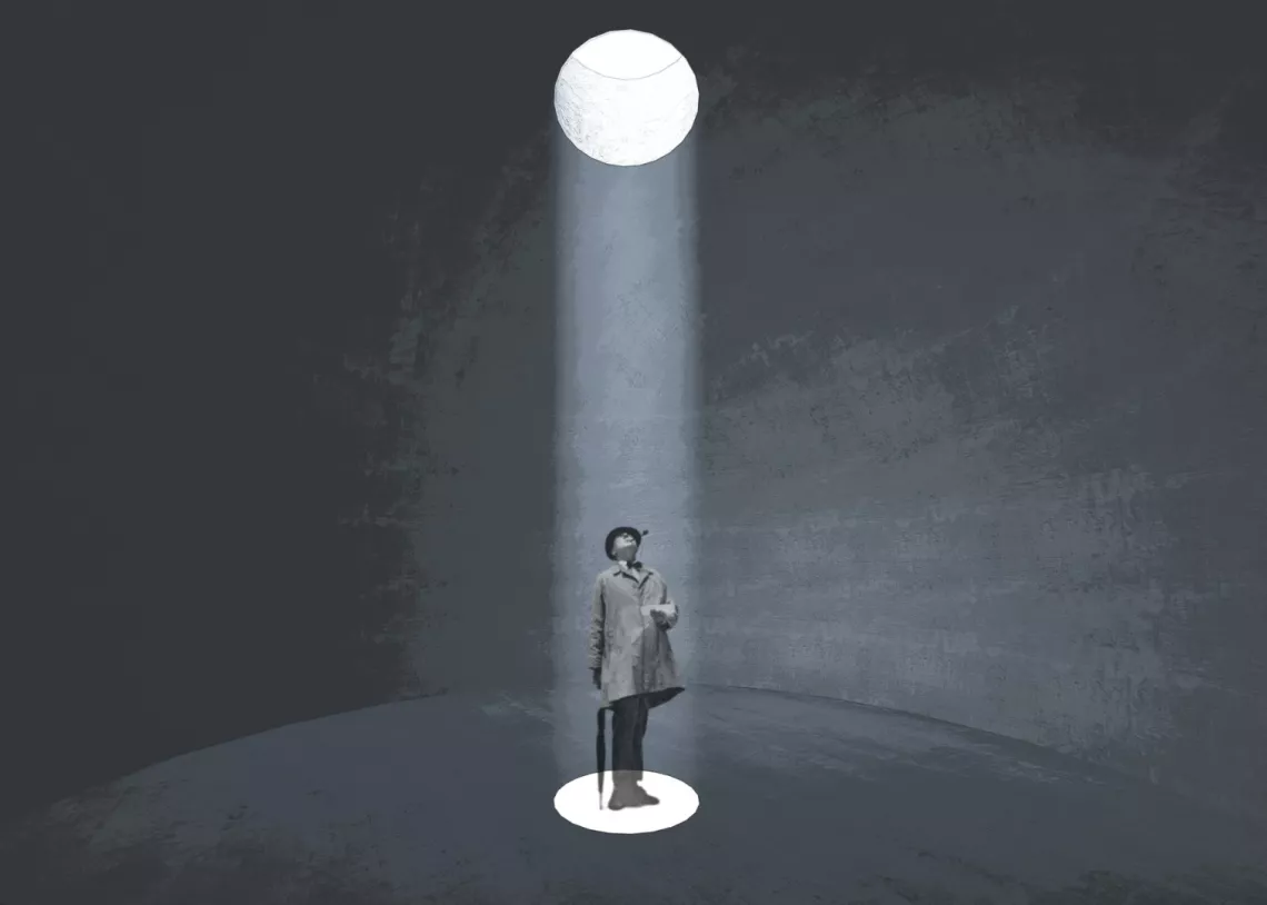 Męzczyzna spoglądający w swiatło padające przez otwór do ciemnego pomieszczenia