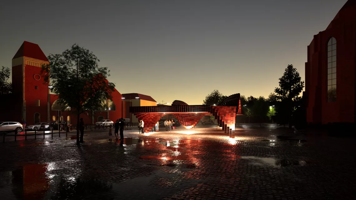 Wizualizacja nocna nowoczesnego pawilonu z cegły, zlokalizowanego na miejskim placu wyłożonym brukiem, po deszczu. Obiekt ma dynamiczną, falującą formę zbudowaną z czerwonych cegieł, tworzących efekt pikselowej struktury. Konstrukcja jest podświetlona od dołu ciepłym światłem, które odbija się w mokrej nawierzchni. Wokół pawilonu spacerują ludzie, w tle widoczne są zabytkowe, ceglane budynki i zaparkowane samochody. Panuje wieczorna, spokojna atmosfera.