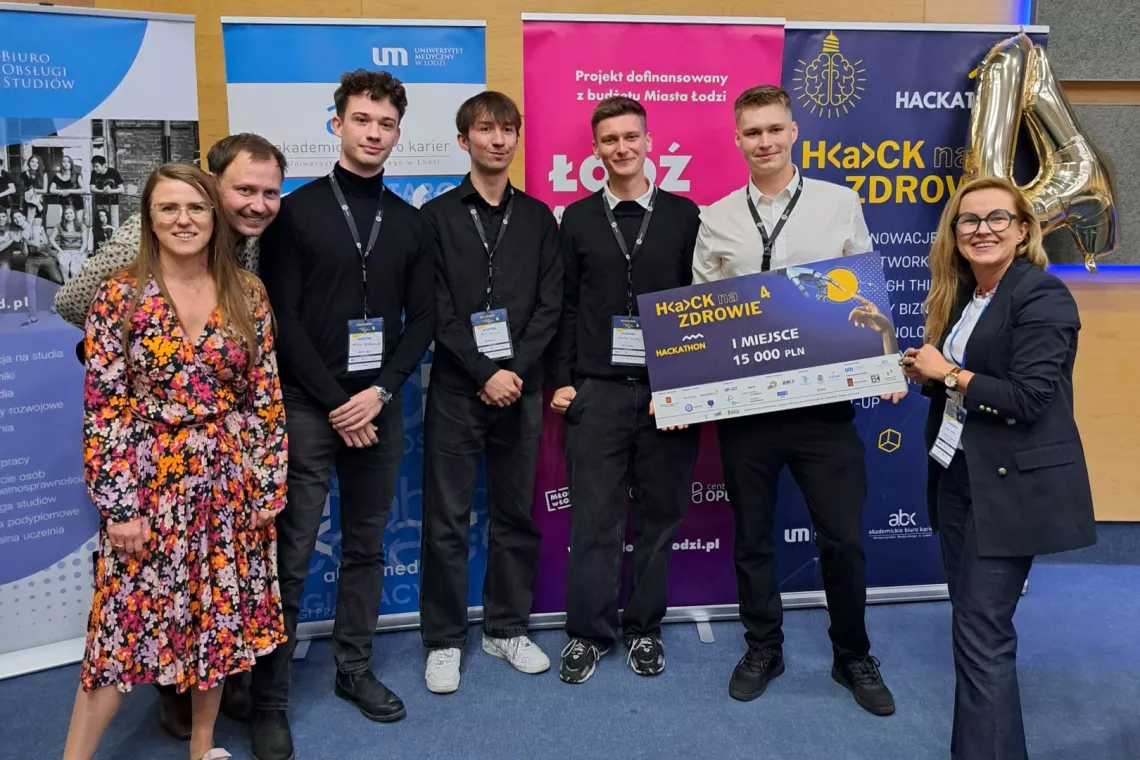 Siedem osób, jedna z nich trzyma czek z napisem I miejce.