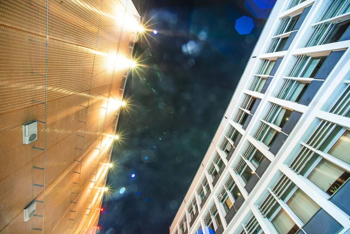 Dwa oświetlone budynki odzielone framentem czarnego nieba