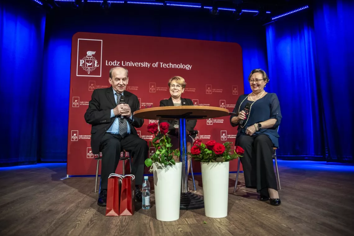 Goście i prowadząca spotkanie siedzą przy stole na tle banera z napisem Politechnika Łódzka