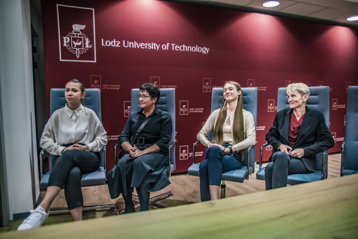 Cztery kobiety sidzą w fotelach za katedra na tle ścianki promocyjnej z napisem Lodz University of Technology