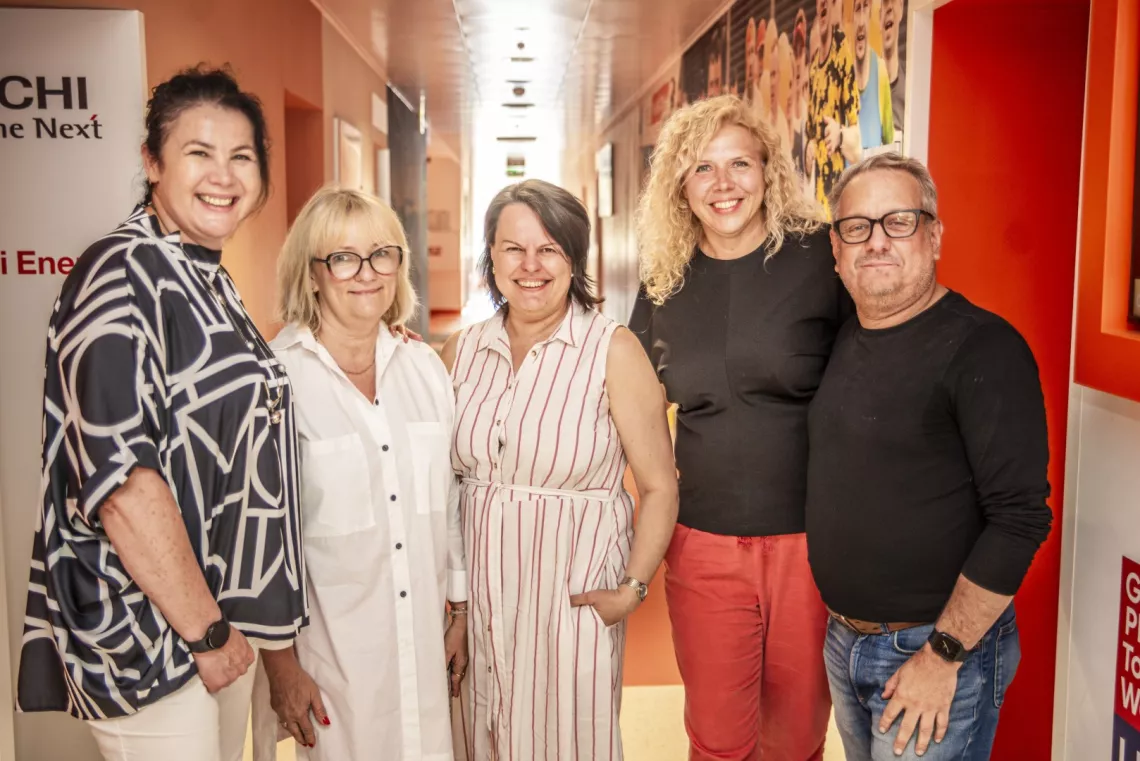 Cztery kobiety i mężczyzna pozują do zdjęcia, stojąc w barwnym korytarzu przed sala gdzie odbywały się zajęcia