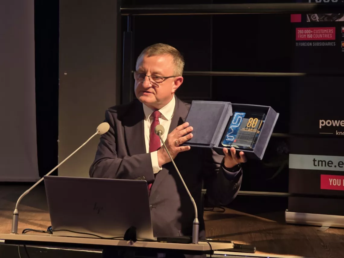 Mężczyzna trzyma statuetkę w ręku i gratuluje z okazji jubileuszu