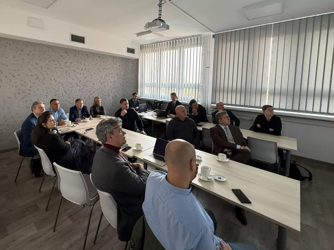 Uczestnicy siedzą w sali seminaryjnej w czasie prezentacji symulacyjnej gry decyzyjnej