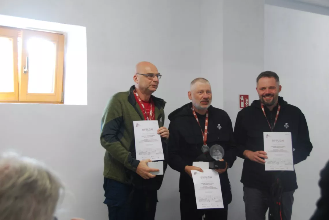 Trzech mężczyzn z medalami i dyplomami