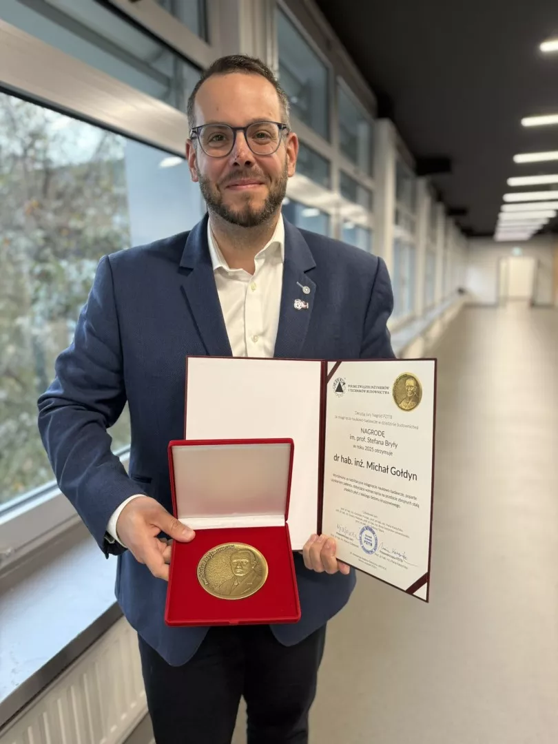 Osoba trzymająca otwarte etui z medalem i dyplom