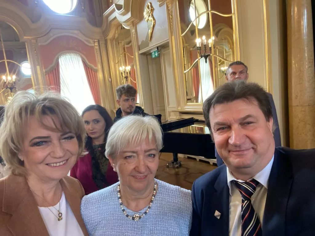 Elegancko ubrane dwie kobiety i mężczyzna w zabytkowym wnętrzu - selfie