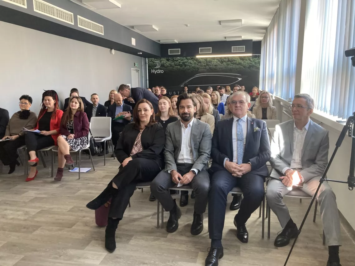 Grupa osób siedzi w sali seminaryjnej