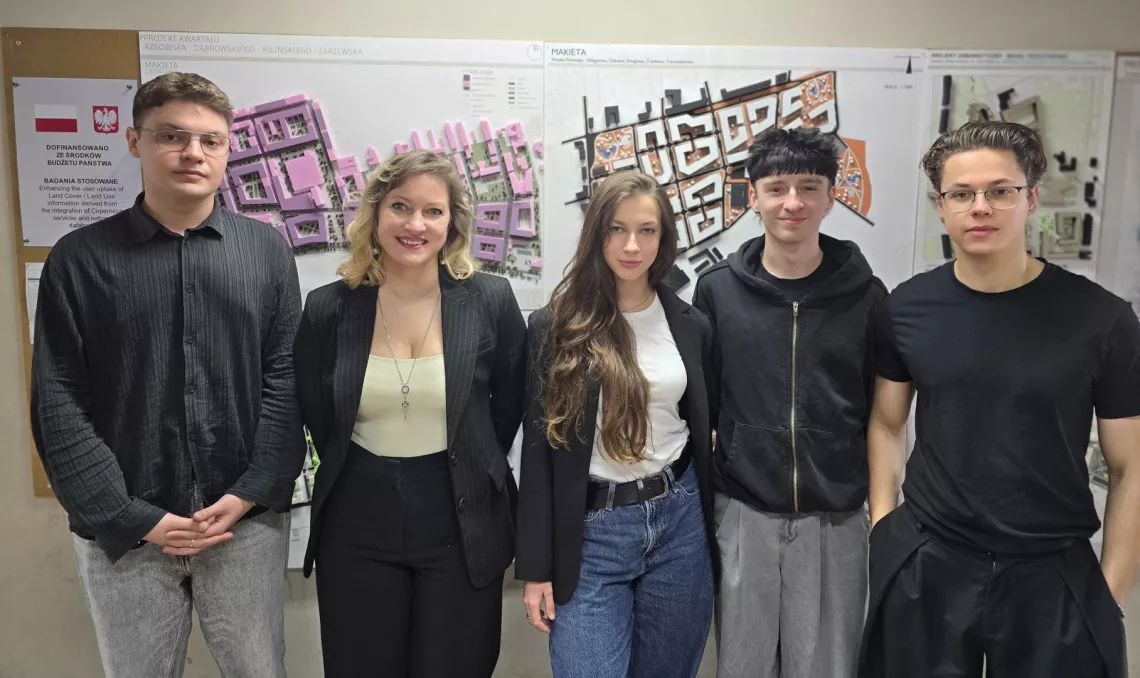 Dwie kobiety i trzech mężczyzn stoi na tle architektonicznego projektu