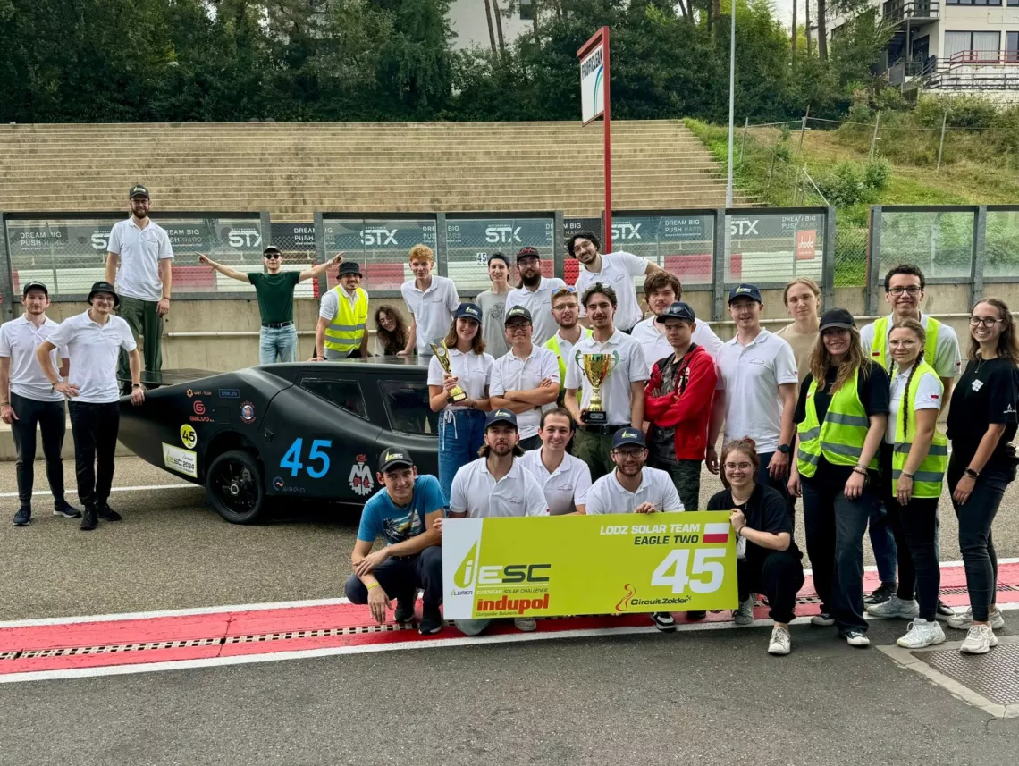 Drużyna z pucharami i z Eagle Two w tle