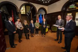 Zespół sześciu osób odbiera gratulacje od rektorów, którzy trzymają w ręku symboliczne czeki za wygraną.