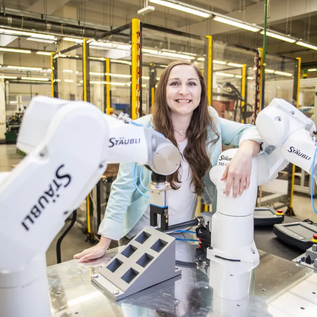 Osoba przy stanowisku z dwoma robotycznymi ramionami Stäubli w laboratorium