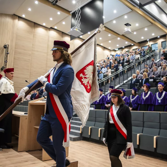 Wejście pocztu sztandarowego na salę wypełnioną uczestnikami spotkania