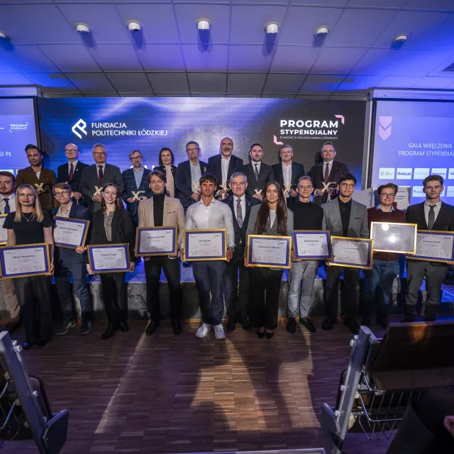 Stypendyści z dyplomami w rękach i mecenasi stypendiów, stojący z tyłu na zbiorowym zdjęciu