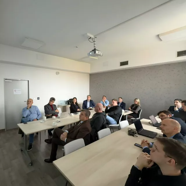 Osoby uczestniczą w prezentacji, prawdopodobnie obserwują obraz na ekranie