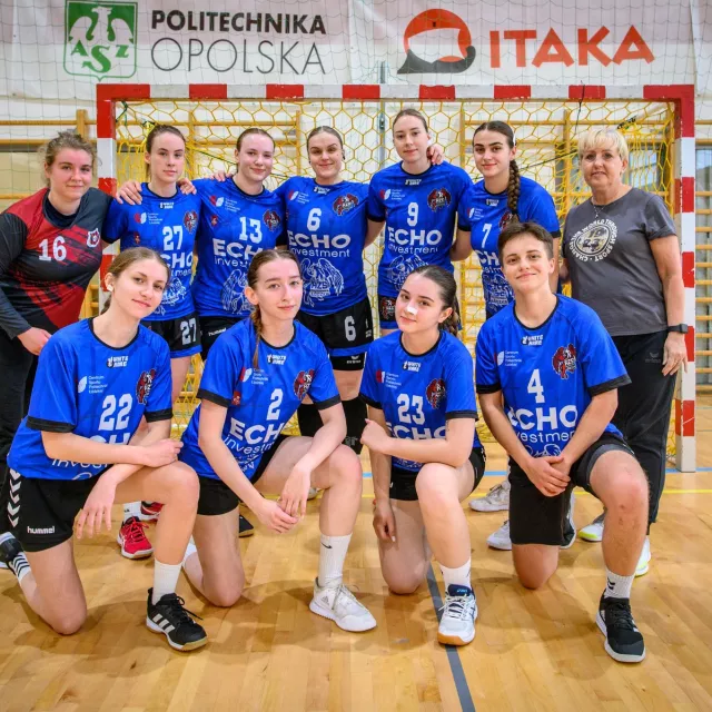 Drużyna szczypiornistek z PŁ na tle bramki w hali sportowej