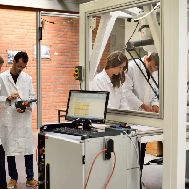 Grupa pracowników w białych fartuchach prowadzi badania w nowoczesnym laboratorium