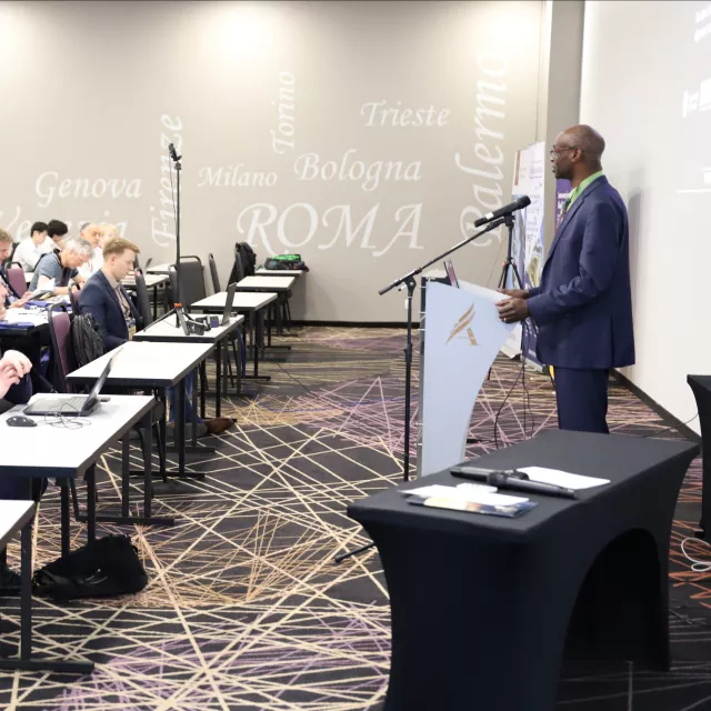 Mężczyzna wygłasza wykład przed słuchaczami w sali seminaryjnej